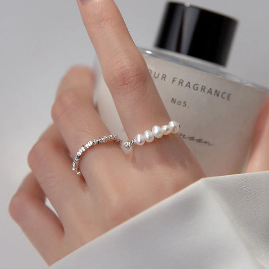 Elegant 925 sterling silver ring featuring a lustrous pearl centerpiece on a sleek geometric band for timeless style.