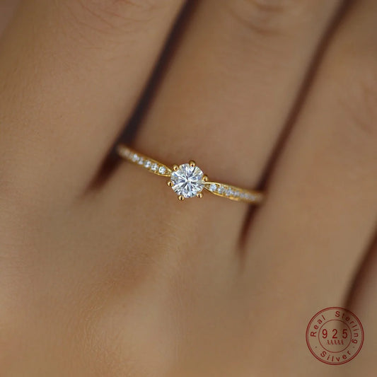 Gleaming 14K gold-plated sterling silver ring with a sparkling 4mm zircon center stone in a sleek geometric band.