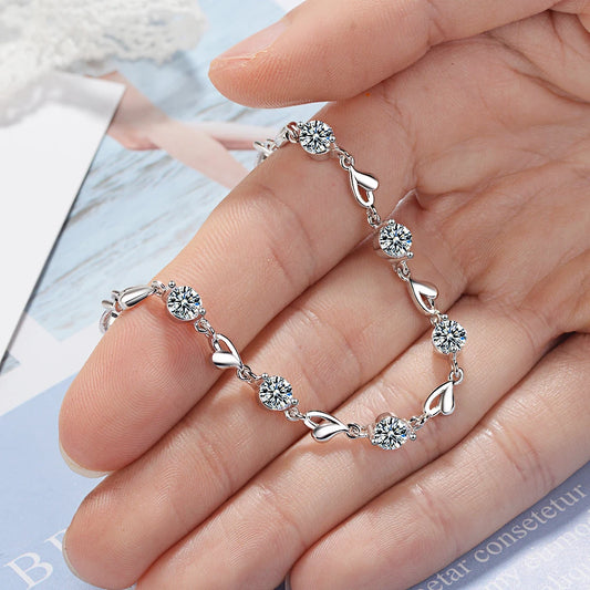 Delicate 925 sterling silver bracelet featuring a heart-shaped design with sparkling zircon crystals for a whimsical charm.