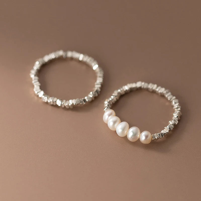 Gleaming 925 sterling silver ring with a lustrous pearl centerpiece, set in a sleek geometric band for elegant style.