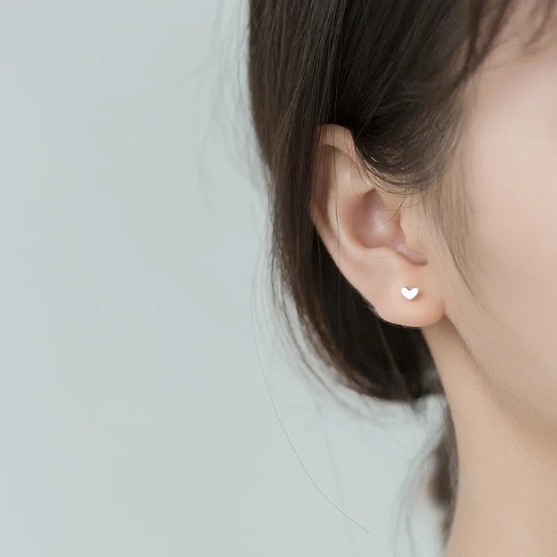Delicate 925 Sterling Silver Mini Love Heart Stud Earrings with a chic, minimalist geometric design for everyday elegance.