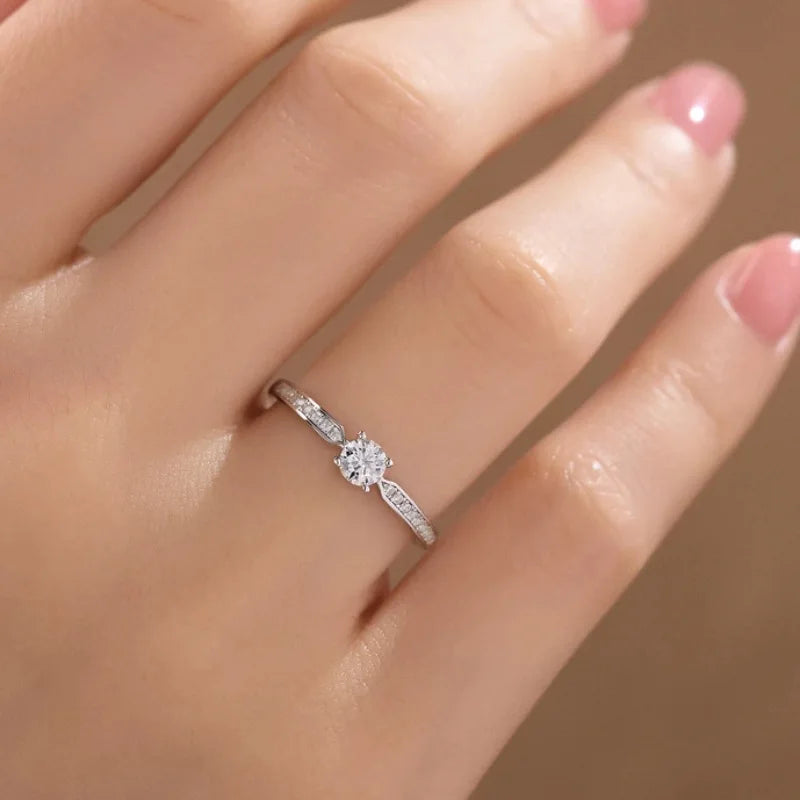 Elegant 925 sterling silver bridal ring set featuring a sparkling 5mm round brilliant moissanite in a classic 4-prong solitaire setting.