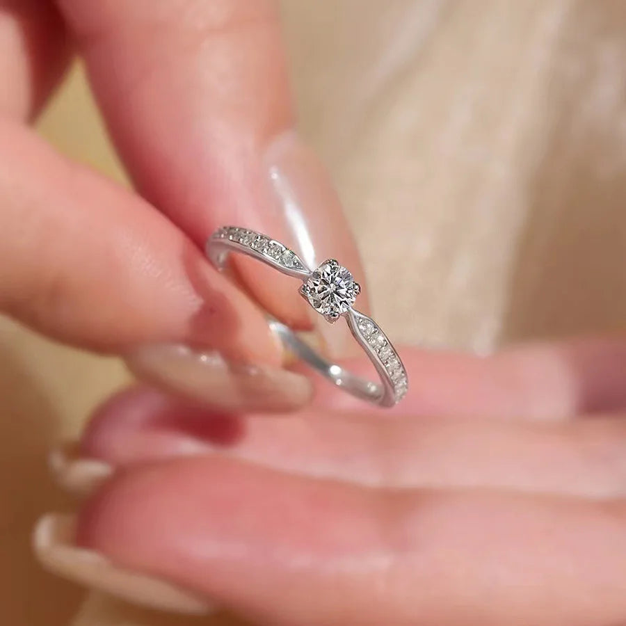 Elegant 925 sterling silver bridal ring set featuring a sparkling 5mm round brilliant moissanite in a classic 4-prong solitaire setting.