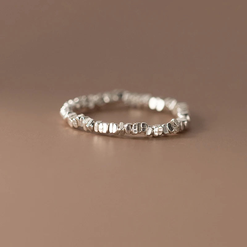 Delicate 925 sterling silver ring with a lustrous pearl centerpiece, set in a sleek geometric band for timeless elegance.