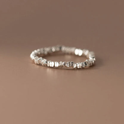 Delicate 925 sterling silver ring with a lustrous pearl centerpiece, set in a sleek geometric band for timeless elegance.