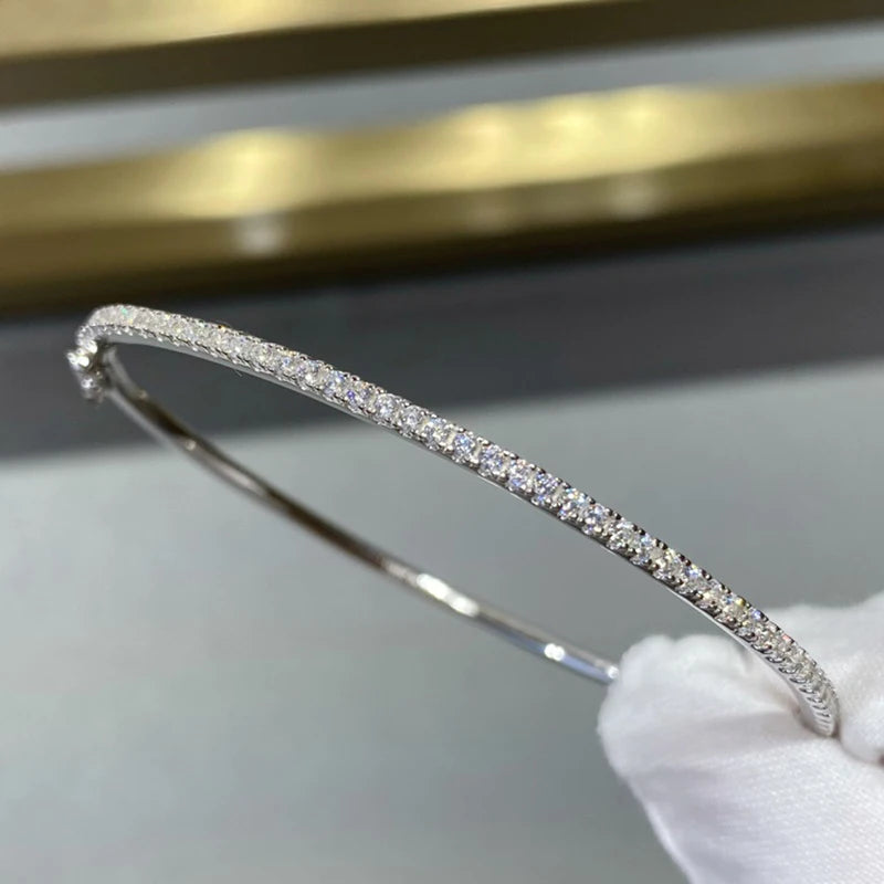 Gleaming gold-filled sterling silver bangle with a sparkling zircon stone centerpiece, showcasing minimalist elegance.