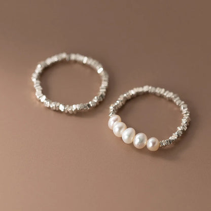 Gleaming 925 sterling silver ring with a lustrous pearl centerpiece, set in a sleek geometric band for elegant style.