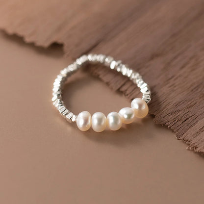 Gleaming 925 sterling silver ring with a lustrous pearl centerpiece, showcasing a minimalist, elegant geometric band.