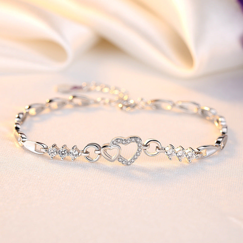 Delicate 925 sterling silver bracelet featuring shimmering purple crystal zircon hearts, perfect for romantic occasions.