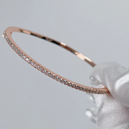 Elegant gold-filled sterling silver bangle with a sparkling prong-set zircon stone, showcasing a minimalist 6cm round design.
