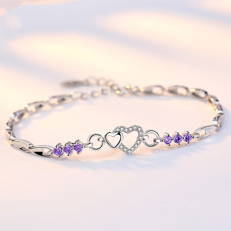 Delicate 925 sterling silver bracelet with shimmering purple crystal zircon hearts, perfect for romantic occasions.